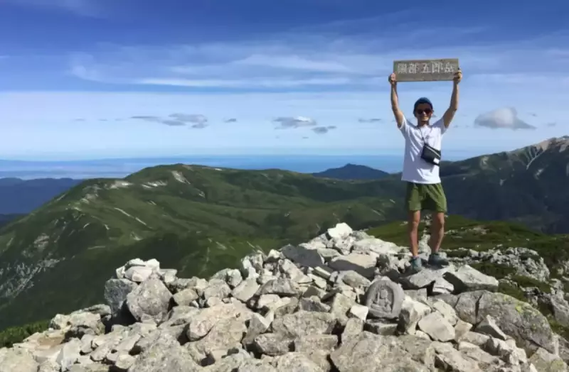 黒部五郎岳山頂に立つ登山者
