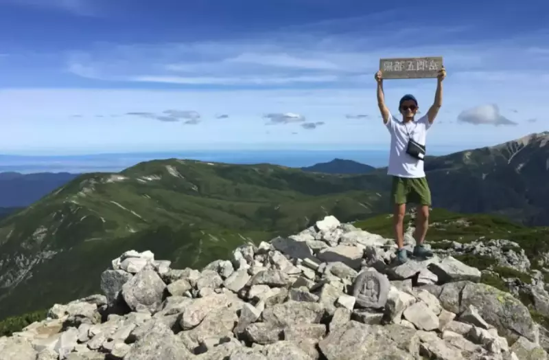 黒部五郎岳山頂に立つ登山者